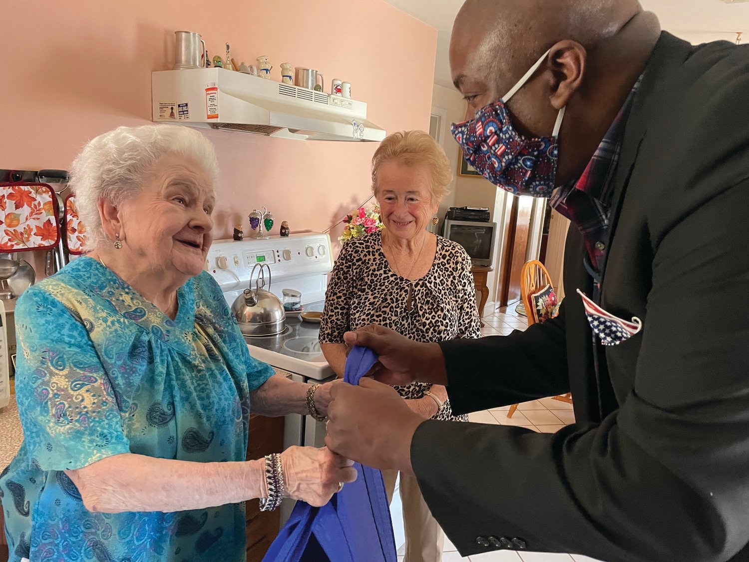 BREAKING BREAD: RI Veteran Affairs Director Kasim Yarn presents Meals on Wheels recipient Theresa Brennan with her meals last week, and thanking her for her late husband’s service.